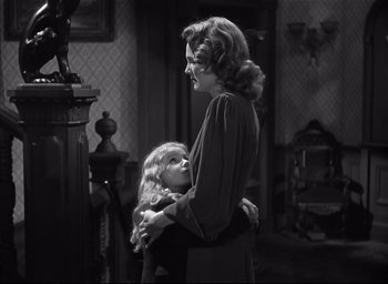 Movie still from “The Curse of the Cat People” (1944), directed by Robert Wise – An old photo of a woman and a little girl hugging; Medium shot, Over the shoulder angle