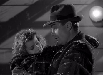 Movie still from “The Curse of the Cat People” (1944), directed by Robert Wise – A man and a little girl are hugging in the snow; Medium shot, Low angle