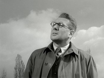 Movie still from “The Dam Busters” (1955), directed by Michael Anderson – An older man wearing glasses and a jacket; Close Up shot, Low angle