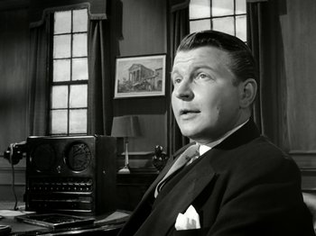 Movie still from “The Dam Busters” (1955), directed by Michael Anderson – An older man sitting in front of an old fashioned radio; Close Up shot, Low angle