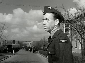 Movie still from “The Dam Busters” (1955), directed by Michael Anderson – An old photo of a man in a military uniform; Medium shot, Low angle