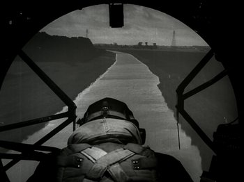 Movie still from “The Dam Busters” (1955), directed by Michael Anderson – A person in a helicopter looking down at a runway; Wide shot, High angle