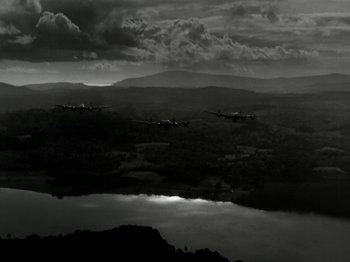 Movie still from “The Dam Busters” (1955), directed by Michael Anderson – A group of planes flying over a body of water; Extreme Wide shot, High angle
