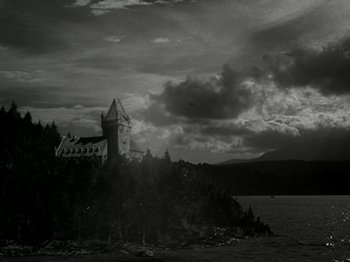 Movie still from “The Dam Busters” (1955), directed by Michael Anderson – A black - and - white photo of a castle on a hill; Extreme Wide shot, Low angle