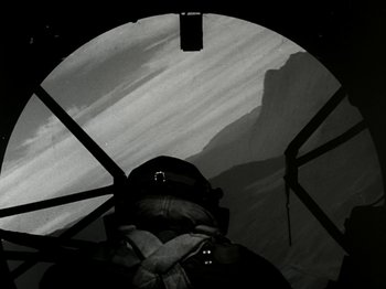 Movie still from “The Dam Busters” (1955), directed by Michael Anderson – A black - and - white photo of a man in a helicopter; Wide shot, Low angle