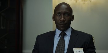 Movie still from “House of Cards” (2013), created by Beau Willimon – A man in a suit and tie with a name tag on his shirt; Close Up shot, Low angle