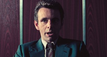 Movie still from “The Damned United” (2009), directed by Tom Hooper – A person wearing a suit and tie; Close Up shot, Over the shoulder angle