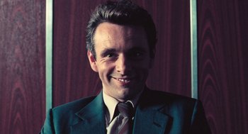 Movie still from “The Damned United” (2009), directed by Tom Hooper – A person wearing a suit and tie; Close Up shot, High angle