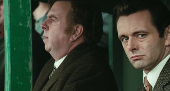 Movie still from “The Damned United” (2009), directed by Tom Hooper – Three men in suits sitting next to each other; Close Up shot, Over the shoulder angle