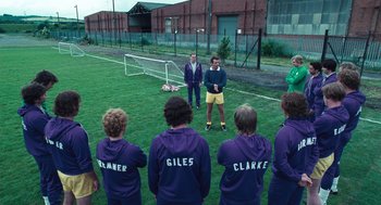 Movie still from “The Damned United” (2009), directed by Tom Hooper – A group of young men standing on top of a soccer field; Wide shot, High angle