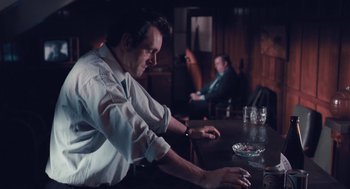 Movie still from “The Damned United” (2009), directed by Tom Hooper – A man sitting at a table in front of a laptop computer; Medium shot, Over the shoulder angle