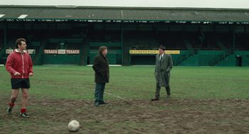 Movie still from “The Damned United” (2009), directed by Tom Hooper – Two men standing in a field next to a soccer ball; Wide shot, High angle