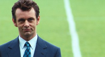 Movie still from “The Damned United” (2009), directed by Tom Hooper – A person wearing a suit and tie; Close Up shot, Low angle