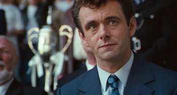 Movie still from “The Damned United” (2009), directed by Tom Hooper – A person wearing a suit and tie; Close Up shot, Over the shoulder angle
