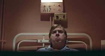 Movie still from “The Damned United” (2009), directed by Tom Hooper – A man in a striped shirt looking up at the ceiling; Close Up shot, Low angle