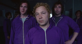 Movie still from “The Damned United” (2009), directed by Tom Hooper – A man in a purple jacket and two other men in a purple jacket; Medium shot, Low angle