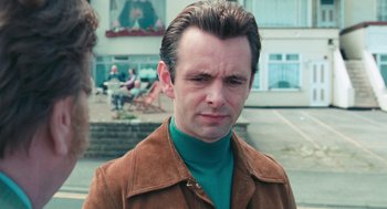 Movie still from “The Damned United” (2009), directed by Tom Hooper – A man in a brown jacket and a green shirt; Close Up shot, Over the shoulder angle