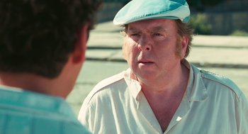 Movie still from “The Damned United” (2009), directed by Tom Hooper – A man wearing a hat talking to another man; Close Up shot, Over the shoulder angle