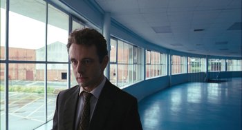 Movie still from “The Damned United” (2009), directed by Tom Hooper – A man wearing a suit and tie standing in front of windows; Close Up shot, Low angle