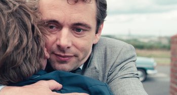 Movie still from “The Damned United” (2009), directed by Tom Hooper – A person holding a child; Close Up shot, Over the shoulder angle