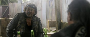 Movie still from “The Dark Horse” (2014), directed by James Napier Robertson – A man sitting at a table with two beer bottles in front of him; Medium shot, Over the shoulder angle