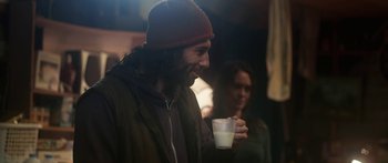 Movie still from “The Dark Horse” (2014), directed by James Napier Robertson – A man holding a cup of coffee while standing next to a woman; Medium shot, Over the shoulder angle