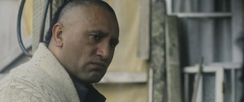 Movie still from “The Dark Horse” (2014), directed by James Napier Robertson – A person wearing a jacket; Close Up shot, Over the shoulder angle