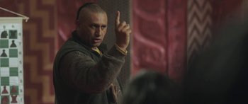 Movie still from “The Dark Horse” (2014), directed by James Napier Robertson – A man with a shaved head is pointing up; Close Up shot, Over the shoulder angle