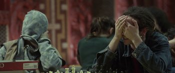 Movie still from “The Dark Horse” (2014), directed by James Napier Robertson – A person sitting at a table playing chess; Close Up shot, Over the shoulder angle