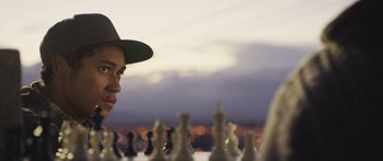 Movie still from “The Dark Horse” (2014), directed by James Napier Robertson – A man in a hat is looking at a chess board; Close Up shot, Over the shoulder angle