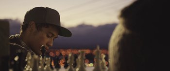 Movie still from “The Dark Horse” (2014), directed by James Napier Robertson – A man in a hat is playing chess outside at night; Close Up shot, Over the shoulder angle