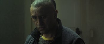 Movie still from “The Dark Horse” (2014), directed by James Napier Robertson – A man with a bald head is looking at the camera; Close Up shot, Over the shoulder angle