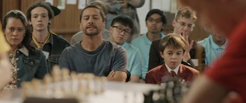 Movie still from “The Dark Horse” (2014), directed by James Napier Robertson – A group of people sitting in front of a table; Medium shot, Over the shoulder angle
