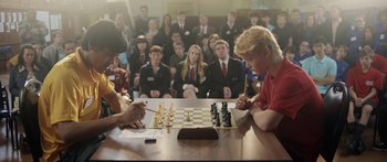 Movie still from “The Dark Horse” (2014), directed by James Napier Robertson – Two people playing a game of chess in front of a crowd; Medium shot, High angle