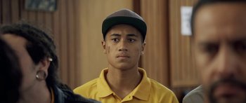 Movie still from “The Dark Horse” (2014), directed by James Napier Robertson – A man in a yellow shirt and a hat; Close Up shot, Over the shoulder angle