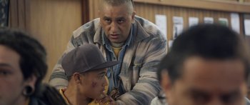 Movie still from “The Dark Horse” (2014), directed by James Napier Robertson – An older man is helping a younger man; Medium shot, Over the shoulder angle