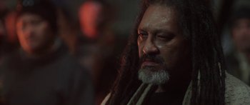 Movie still from “The Dark Horse” (2014), directed by James Napier Robertson – A person with long hair and a beard; Close Up shot, Over the shoulder angle