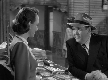 Movie still from “The Dark Mirror” (1946), directed by Robert Siodmak – An old photo of a man and a woman talking to each other; Medium shot, Over the shoulder angle