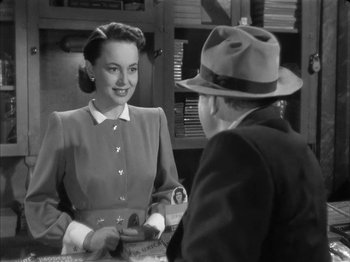 Movie still from “The Dark Mirror” (1946), directed by Robert Siodmak – An old photo of a woman talking to a man; Medium shot, Over the shoulder angle