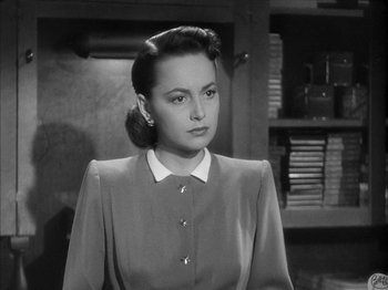 Movie still from “The Dark Mirror” (1946), directed by Robert Siodmak – A black and white photo of a woman in a dress; Close Up shot, Low angle