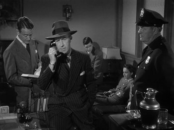 Movie still from “The Dark Mirror” (1946), directed by Robert Siodmak – An old photo of a man talking on a phone; Medium shot, High angle