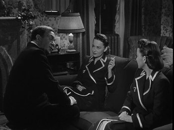 Movie still from “The Dark Mirror” (1946), directed by Robert Siodmak – A man and two women sitting on a couch talking to each other; Medium shot, High angle