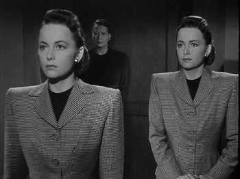 Movie still from “The Dark Mirror” (1946), directed by Robert Siodmak – A black and white photo of two women and a man; Medium shot, Low angle