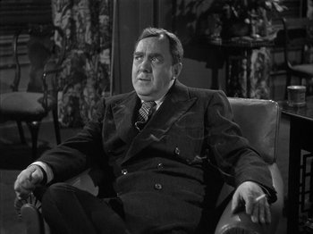 Movie still from “The Dark Mirror” (1946), directed by Robert Siodmak – An older man in a suit sitting in a chair; Close Up shot, High angle