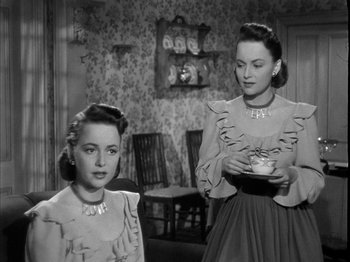 Movie still from “The Dark Mirror” (1946), directed by Robert Siodmak – Two young women are standing next to each other in a room; Medium shot, High angle