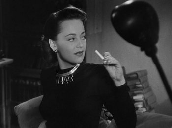 Movie still from “The Dark Mirror” (1946), directed by Robert Siodmak – A black and white photo of a woman smoking a cigarette; Close Up shot, Over the shoulder angle