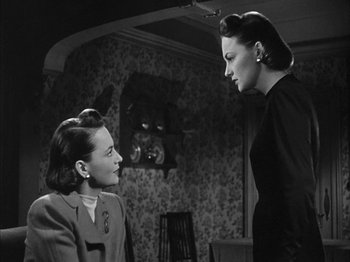 Movie still from “The Dark Mirror” (1946), directed by Robert Siodmak – Two women are talking to each other in a room; Medium shot, Over the shoulder angle