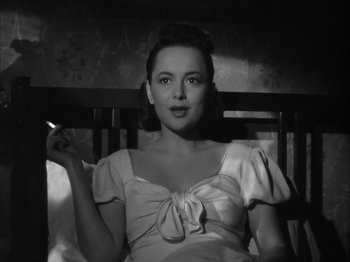 Movie still from “The Dark Mirror” (1946), directed by Robert Siodmak – A black - and - white photo of a woman sitting in a chair; Close Up shot, Low angle
