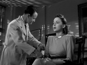 Movie still from “The Dark Mirror” (1946), directed by Robert Siodmak – A man and a woman are shaking hands in an office setting; Medium shot, Low angle