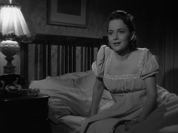 Movie still from “The Dark Mirror” (1946), directed by Robert Siodmak – A woman sitting on a bed in a room; Medium shot, High angle